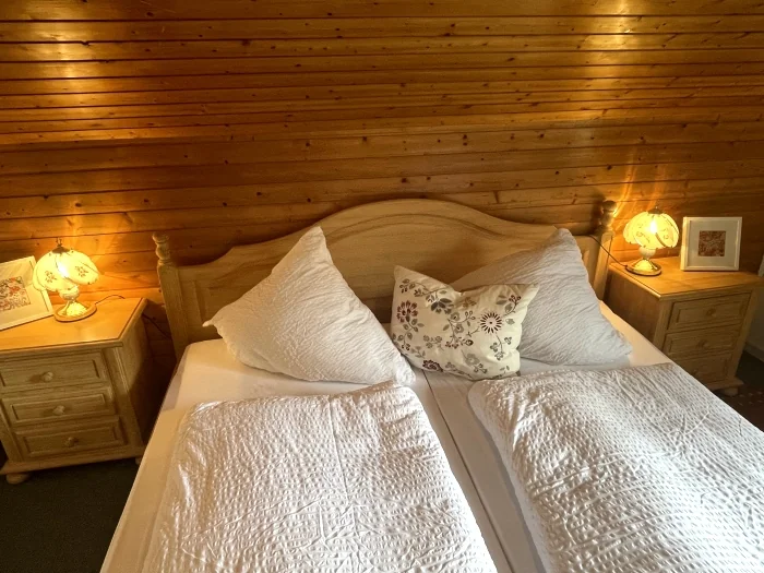Das gemütliche Doppelbett mit warmer Holzverkleidung in der Ferienwohnung Abendstern